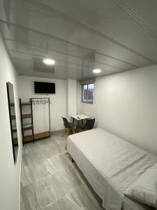 ein Schlafzimmer mit einem Bett, einem Tisch und einem Schreibtisch in der Unterkunft Edificio Cardamomo in Neiva