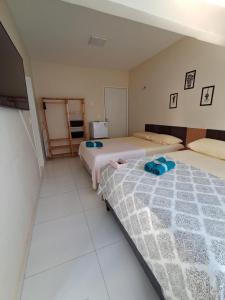 a bedroom with two beds and a tv in it at Pousada Odoyá Beach - Quádrupla in Conde