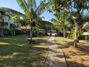 a path through a park with palm trees at Happy Mind Resort in Sam Roi Yot