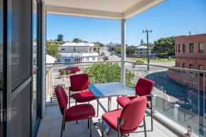 a balcony with chairs and a table and a view of a street at 1 Duke street in Albany