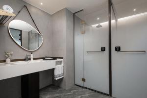 a bathroom with a sink and a mirror at Wanda Moments Beijing Pinggu in Pinggu +19 photos