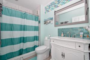 a bathroom with a toilet and a sink and a mirror at Park Place Unit 130 in Cedar Key +7 photos