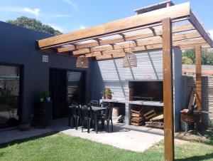 a wooden pergola on a patio with a table and chairs at Lo de Mili in General Juan Madariaga