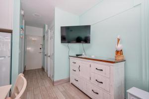 a room with a dresser with a tv on the wall at Park Place Unit 130 in Cedar Key