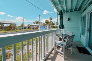 a balcony with a table and an umbrella at Park Place Unit 130 in Cedar Key