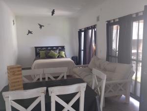 a bedroom with a bed and two chairs and a couch at Lo de Mili in General Juan Madariaga +2 photos