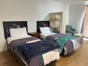 a hotel room with two beds and a chair at Cosy and convenient accommodation in Springvale