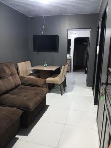a living room with a couch and a table at Casa inteira in Ponta Grossa