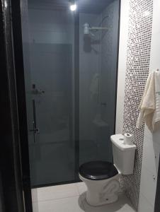 a bathroom with a toilet with a glass shower at Casa inteira in Ponta Grossa +3 photos