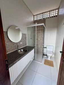 a bathroom with a sink and a toilet and a mirror at Pousada do Horto in Juazeiro do Norte