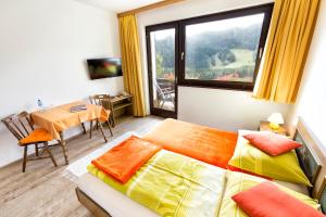 a bedroom with a bed and a window and a table at Bed&Breakfast Lausegger in Ferlach