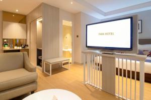 a living room with a television on a table at Park Hotel in Xiamen +11 photos