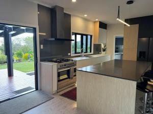 a kitchen with a stove and a counter top at Taratara retreat in Kaeo