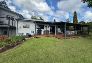 a large house with a large deck in the yard at Taratara retreat in Kaeo