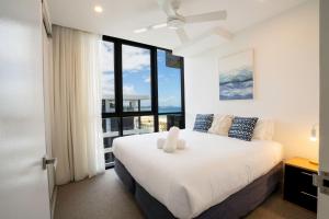 a bedroom with a large bed with a large window at Iconic Kirra Beach Resort in Gold Coast +167 photos