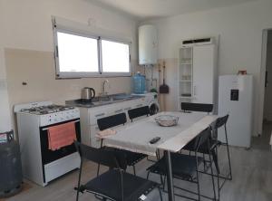 a kitchen with a table with chairs and a stove at Mountain View & Comfort in Villa Santa Cruz del Lago