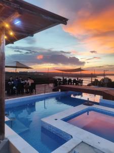 a swimming pool with a sunset in the background at JK Beach Club Bar e Pousada in Ibiúna +17 photos