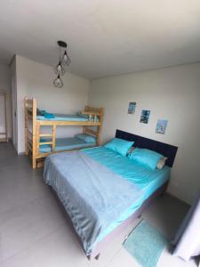 a bedroom with a bed and bunk beds in it at JK Beach Club Bar e Pousada in Ibiúna