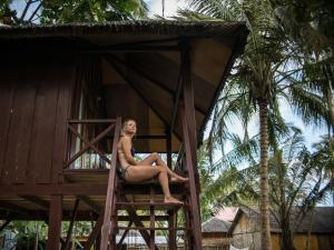 a woman sitting in a tree house at Simeulue Surflodges in Lasikin
