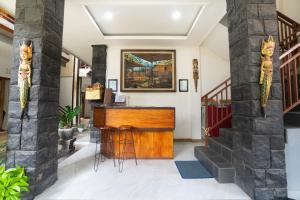 a lobby with a wooden console and stairs at Pak Vo House by The Travel Ubud Bali in Ubud +96 photos