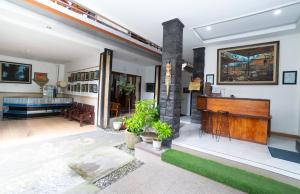 a living room with a piano in a house at Pak Vo House by The Travel Ubud Bali in Ubud