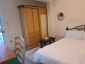 a bedroom with a bed and a wooden cabinet at 包棟Linsen Secret Realm 27 in Tainan
