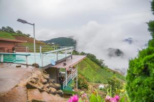 a house on the side of a hill with clouds at MonLanna Homesty in Ban Thung Pa Haeo
