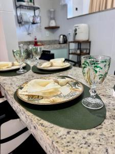 a table with plates and glasses on a counter at Studio 12 in Santa Cruz Cabrália