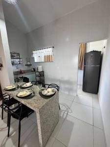 a kitchen with a table and a refrigerator at Studio 12 in Santa Cruz Cabrália +3 photos