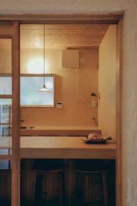 Eine Küche mit einer Theke, an der ein Tisch und eine Lampe befestigt sind. in der Unterkunft 一棟貸しヴィラmatai in Kitsuki + 28 Fotos