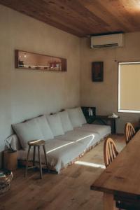 ein Bett in einem Zimmer mit Tisch und Stühlen in der Unterkunft 一棟貸しヴィラmatai in Kitsuki