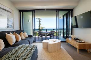 a living room with a couch and a table at Iconic Kirra Beach Resort in Gold Coast
