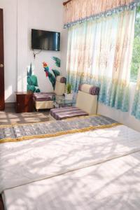 a bedroom with a bed and a living room at Nam Phương Hotel Sa Đéc in Sa Ðéc
