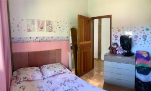 a bedroom with a pink bed and a dresser at Refúgio da Nicinha a 7 min do Centro Histórico in Paraty +18 photos