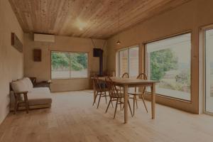 ein Esszimmer mit einem Holztisch und Stühlen in der Unterkunft 一棟貸しヴィラmatai in Kitsuki