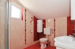a bathroom with a toilet and a sink and a window at Apartmani P&M in Tivat +14 photos