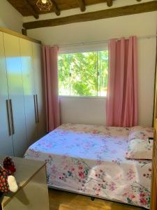 a bedroom with a bed and a window at Refúgio da Nicinha a 7 min do Centro Histórico in Paraty