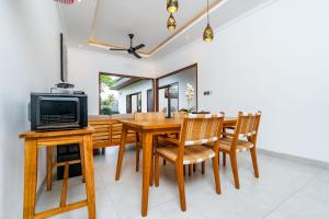 a dining room with a wooden table and chairs at Made Ubud Villa by Bali Cabin in Ubud