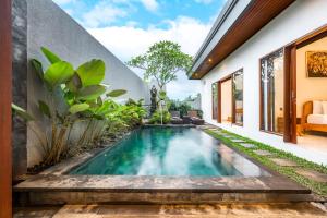 an infinity pool in the backyard of a house at Made Ubud Villa by Bali Cabin in Ubud