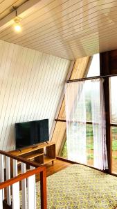 a room with a flat screen tv in a tent at Padangsari Cabin 2 in Diyeng