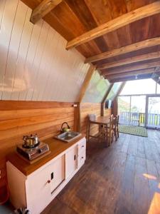 a kitchen in a cabin with a sink and a table at Padangsari Cabin 2 in Diyeng