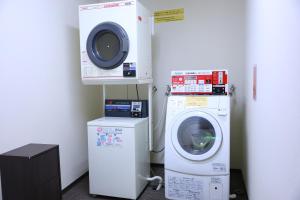 a laundry room with a dryer and a washing machine at Hotel Takimoto in Yamanouchi