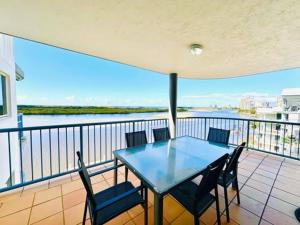 a table and chairs on a balcony with a view of the water at On The River Apartments in Maroochydore
