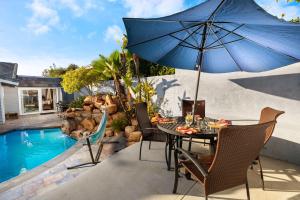 a table with an umbrella next to a swimming pool at Stunning View Estate with Pool & Game Room in La Mesa