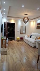 a living room with a white couch and wooden floors at Casa do sossego in Cabo Frio