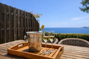 a tray with two glasses of wine on a table at Beachfront Villa Cannes I Garden - Terrace & Sea View -Prime Location- Free Parking in Cannes