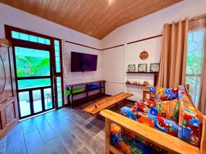 a living room with a couch and a tv at Casa Del Bambu in Puerto Jiménez