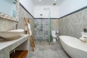 a bathroom with a tub and a sink and a shower at Made Ubud Villa by Bali Cabin in Ubud +14 photos