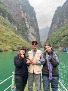 three people standing on a bridge near a river at Ha Giang SkyPath Hostel & Tours in Làng Lap +20 photos