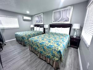 a hotel room with two beds and two windows at Lemon Bay Motel in Englewood